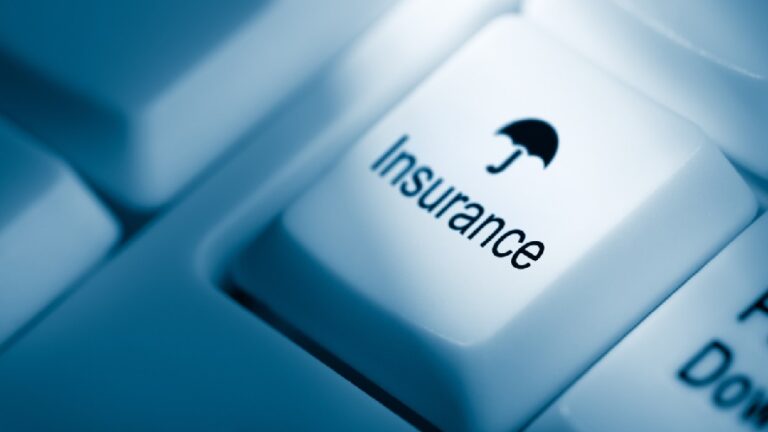 Close-up of a white computer keyboard button featuring the word "Insurance" and an umbrella icon, perfect for an online Health Insurance Shop.