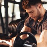 Exercise Addiction concept showing a man intensely lifting weights in a gym, highlighting excessive workout behavior and fitness obsession.