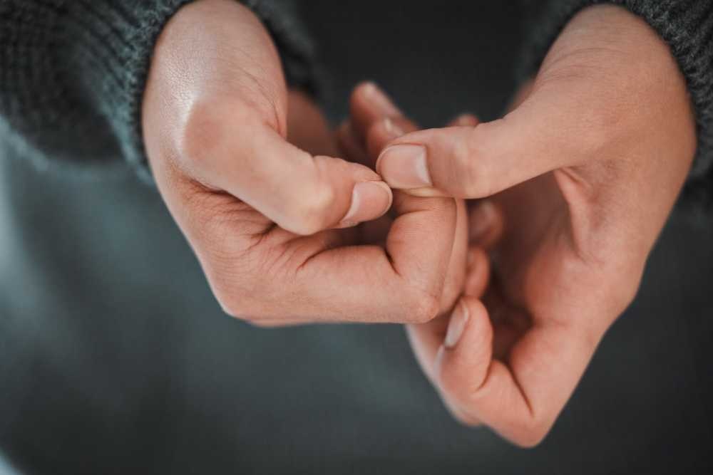 Close-up of anxious hands fidgeting, representing the internal stress and guilt associated with Lying in addiction recovery.