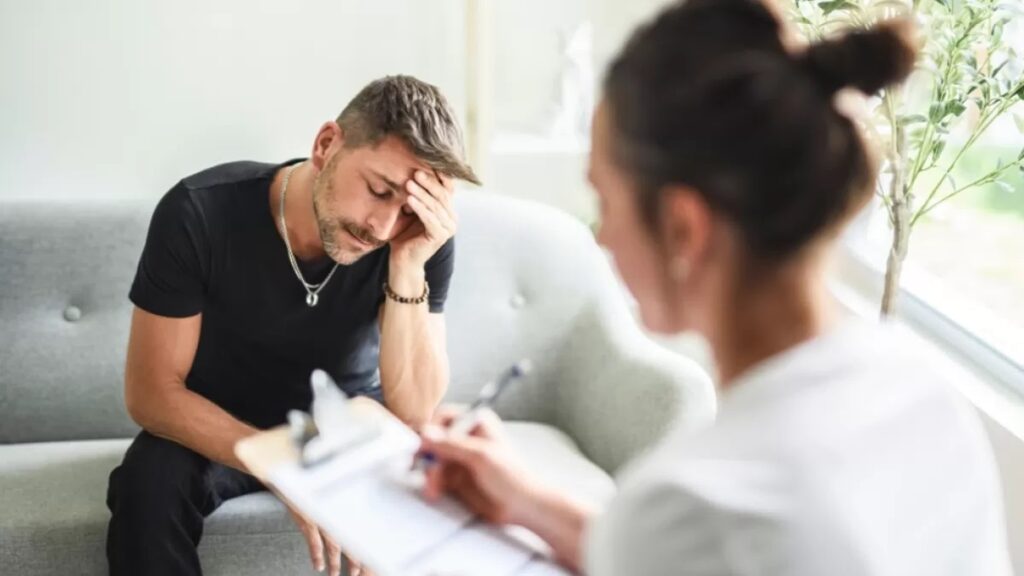 A stressed man consulting with a healthcare professional, showing how addiction is a medical condition requiring expert care.