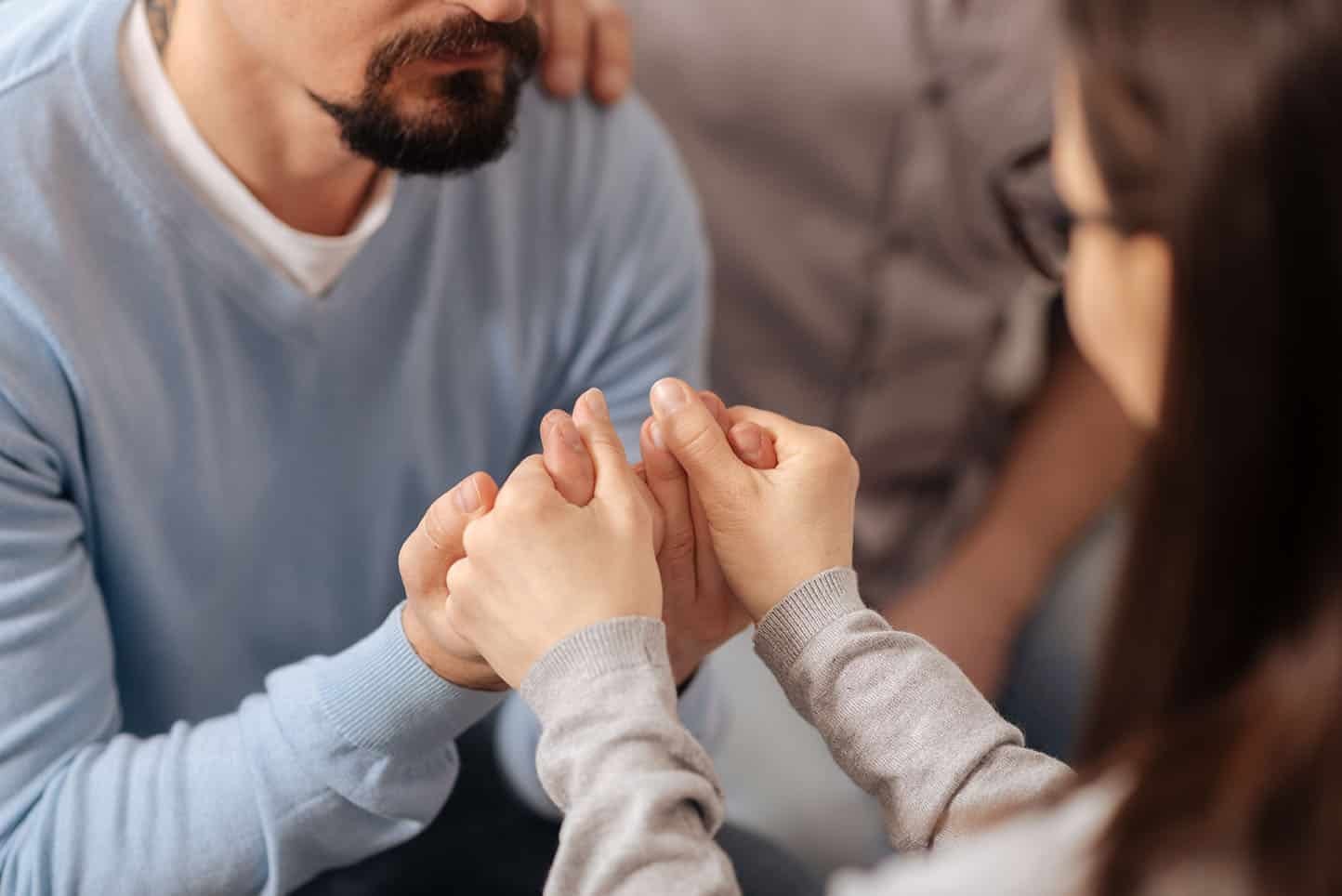 Supportive hands hold each other during a compassionate recovery session at a Fort Wayne Drug Rehab center.