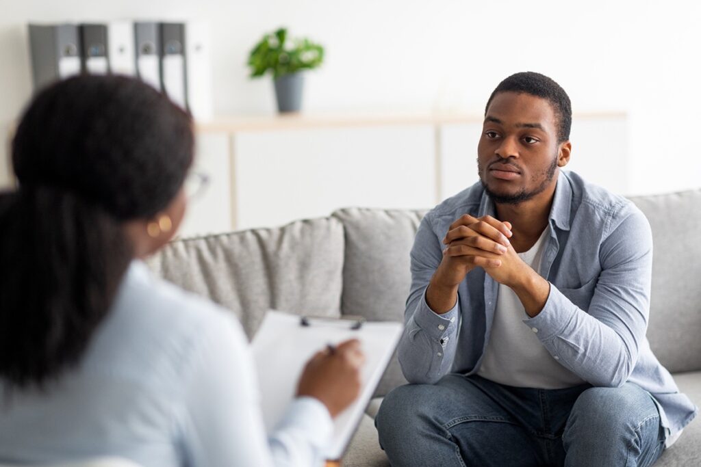 A young man speaking with a counselor during an individual therapy session in the best residential rehab program.