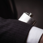 Close-up of a worker hiding a flask in their sleeve, illustrating the hidden signs of hospitality industry alcohol abuse.
