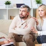 Supportive woman comforting her partner during a therapy session, highlighting family support in addiction recovery