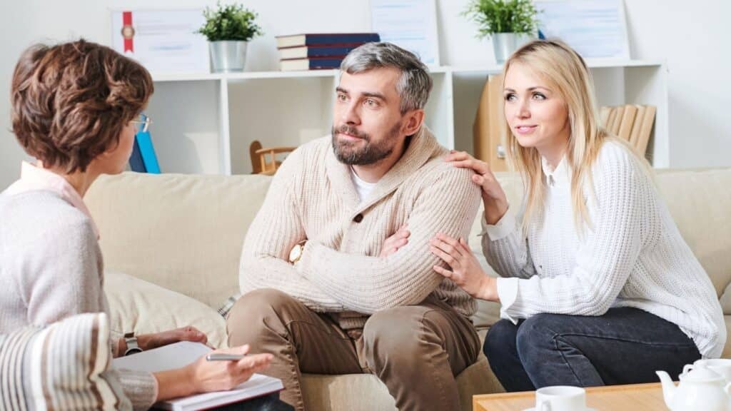 Supportive woman comforting her partner during a therapy session, highlighting family support in addiction recovery