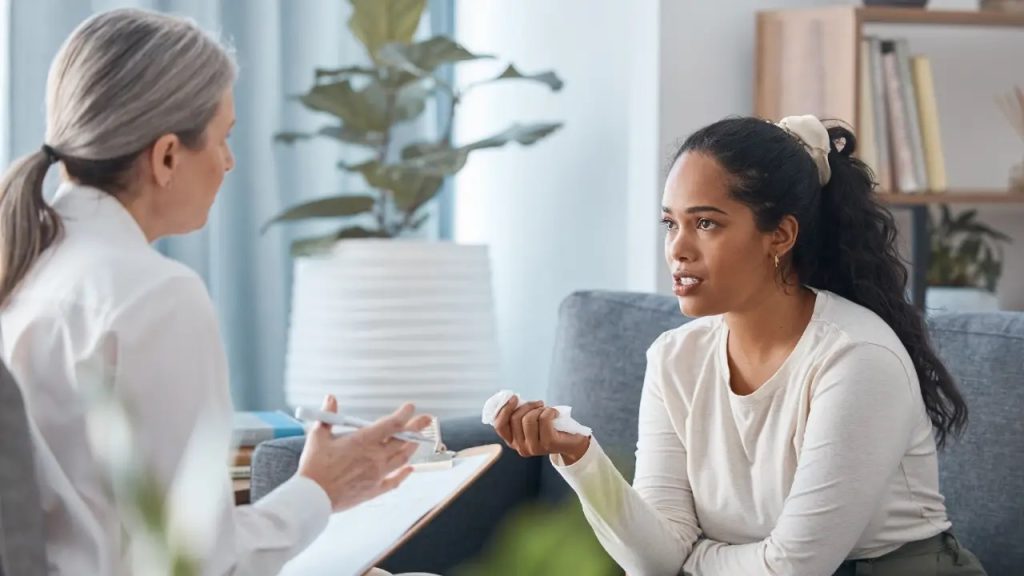 A young woman speaking with a counselor during an evaluation for the Rehab Admission Process.