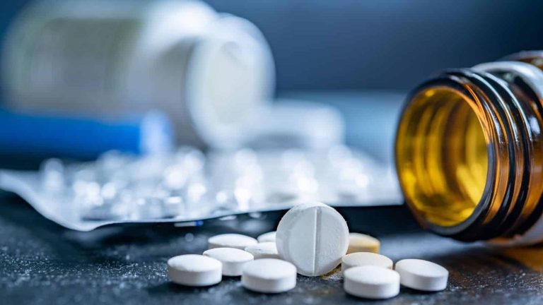 Prescription pills spilling out of a bottle, representing medication management during a structured benzodiazepine detox program.