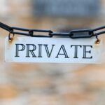 A white private sign hanging on a black chain, representing confidential private rehab for professionals.